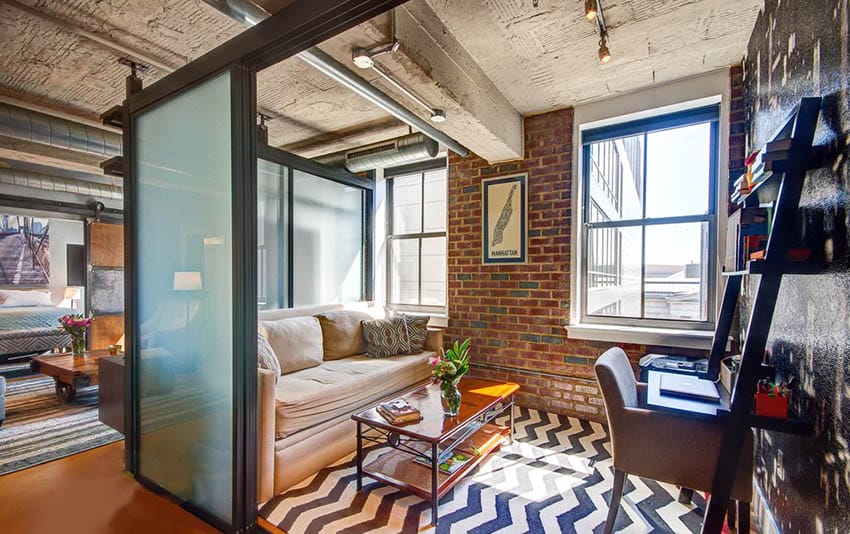 Loft apartment with living room bedroom combo behind frosted glass sliding doors and wood barn doors