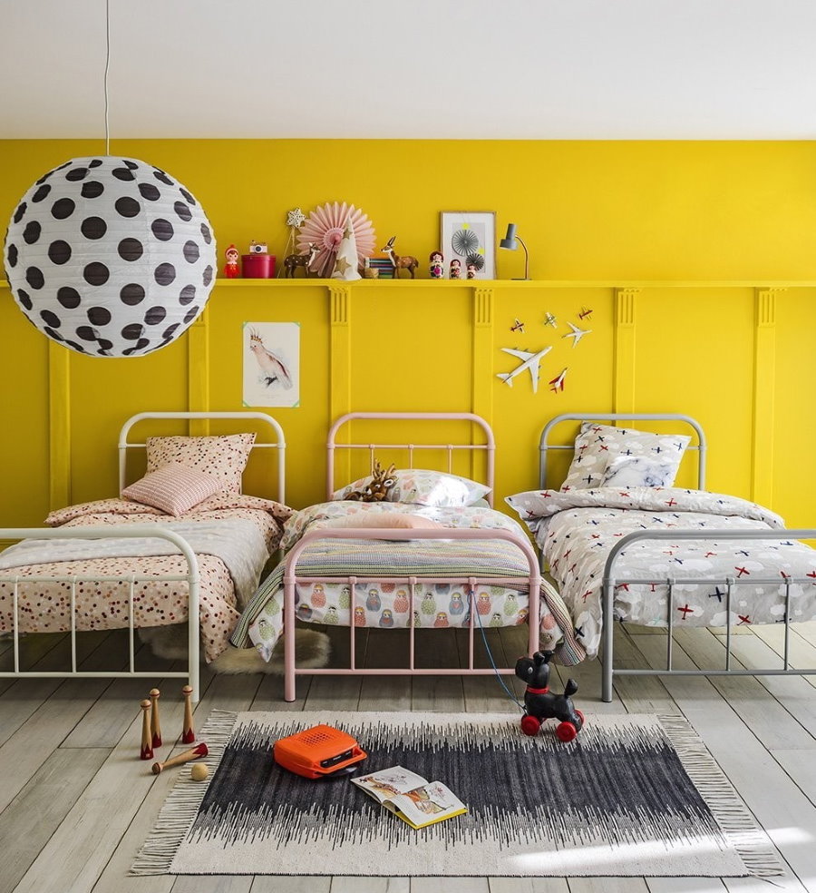 Детские кровати около желтой стены