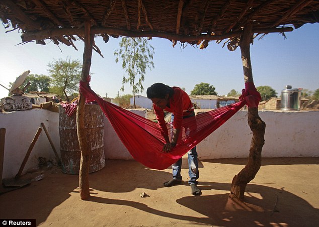 Raising baby: Gopal Kishan, 16, plays with his four-month-old baby Alok who