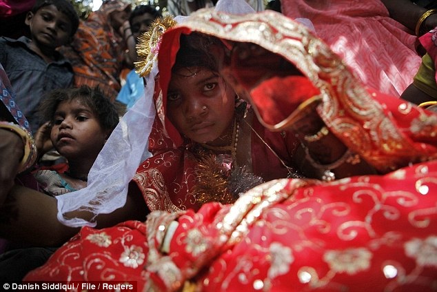 Child bride: At 11-years-old, Krishna peeks out from a wedding veil during her elaborate 2010 ceremony to her future husband Gopal Kishan, aged 13